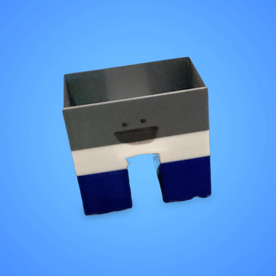 The Classic Deskbuddy — a grey, white, and navy 3D-printed desk organizer with a smiling face